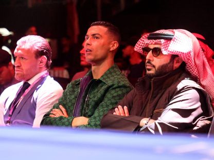 كريستيانو رونالدو يتوسط المستشار تركي آل الشيخ وكونور ماكغريغور خلال مشاهدة نزال أنطونيو جوشوا وأوتو والين - 23 ديسمبر 2023 - Reuters