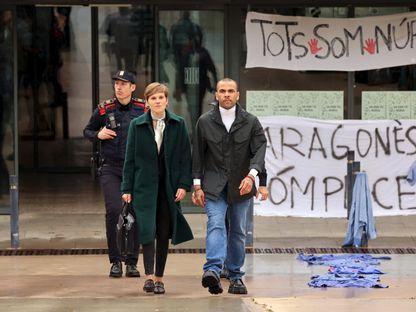 داني ألفيس لدى خروجه من السجن بكفالة مع محاميته إينيس غوارديولا أثناء استئناف إدانته بالاغتصاب في برشلونة - 25 مارس 2024 - Reuters