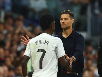 مدرب ريال مدريد تشابي ألونسو مع فينيسيوس جونيور خلال مباراة بين ريال مدريد وبرشلونة - 26 أكتوبر 2025 - REUTERS