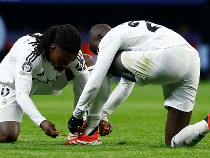 إدوارد كامافينغا يساعد فيرلان ميندي على ربط الحذاء خلال إحدى مباريات ريال مدريد - Reuters