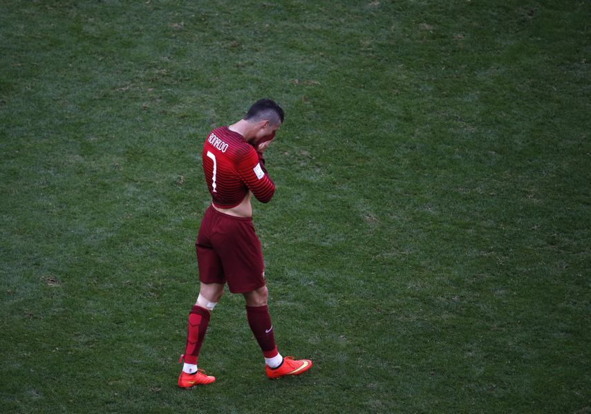 نجم البرتغال كريستيانو رونالدو يخرج حزيناً من الملعب بعد إقصاء منتخب بلاده من دور المجموعات في مونديال 2014 في البرازيل  