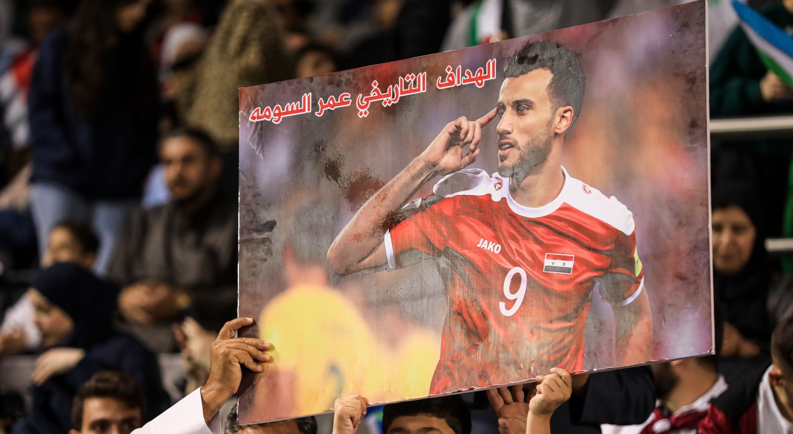 مشجعو سوريا يرفعون صورة الهداف التاريخي للمنتخب عمر السومة خلال مواجهة أوزبكستان في كأس آسيا - 13 يناير 202
