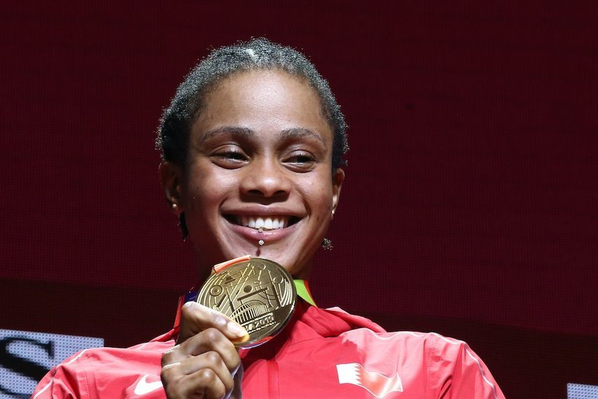 البحرينية سلوى عيد ناصر تقف على منصة التتويج وهي تظهر ميداليتها الذهبية - AFP