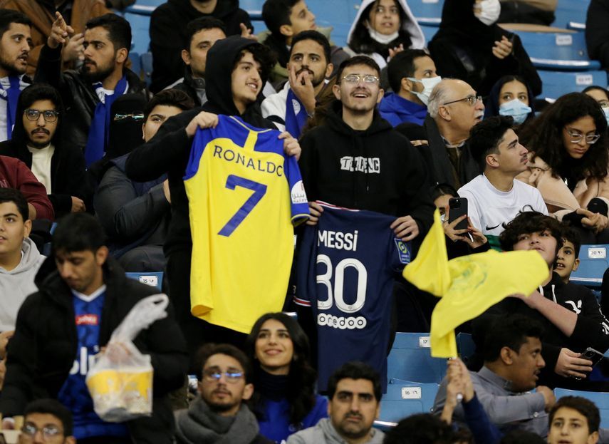 الجماهير تحمل قميصي كريستيانو رونالدو وليونيل ميسي خلال مباراة 