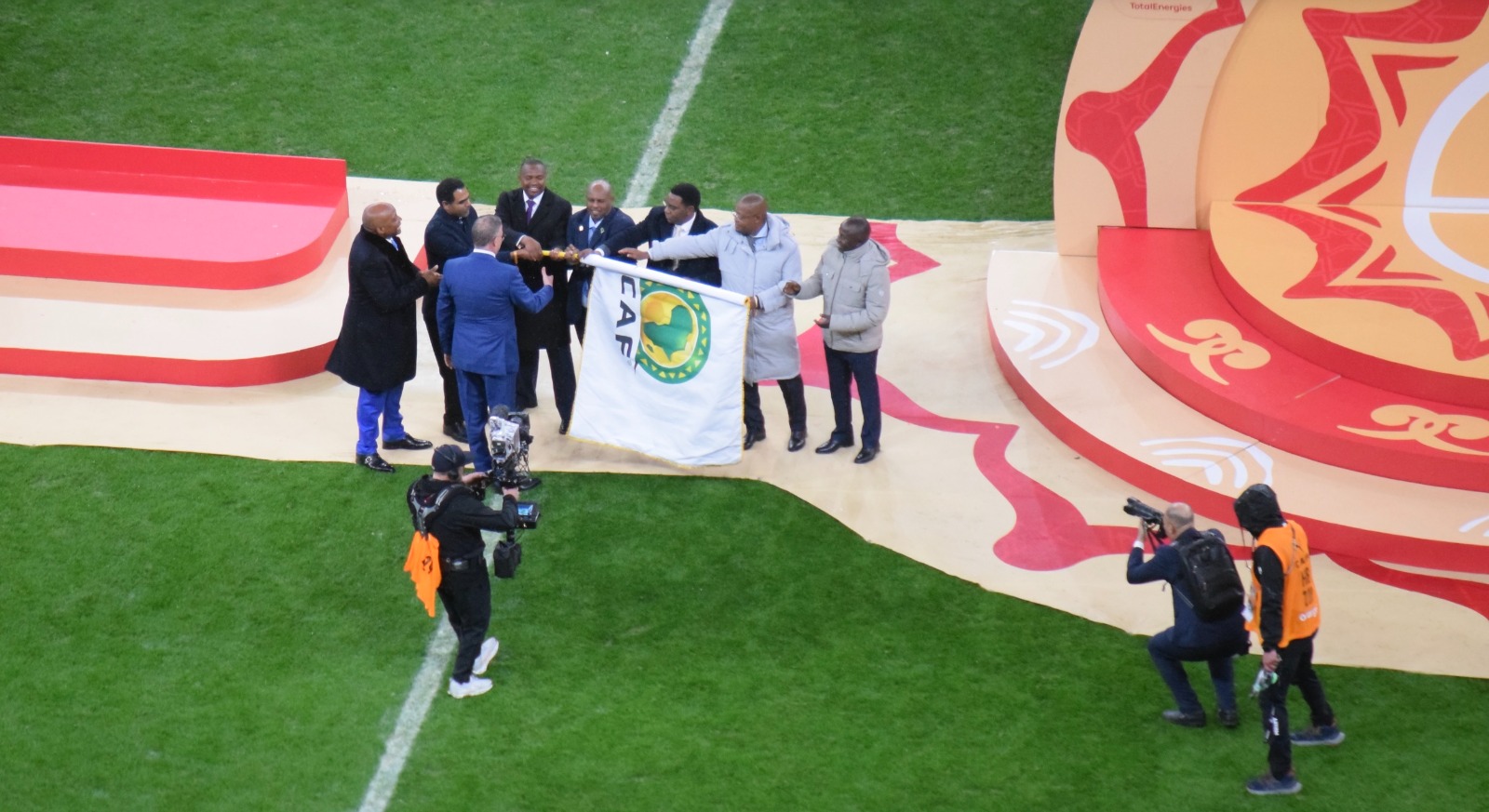 فوزي لقجع رئيس الجامعة الملكية المغربية لكرة القدم يسلم راية كأس أمم إفريقيا إلى وفد تنزانيا وكينيا وأوغندا أثناء مراسم التتويج بنسخة 2025 -  18 يناير 2026