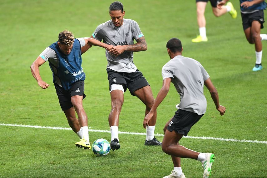 لاعب خط وسط ليفربول الإنجليزي تشامبرلاين (يسار) يصارع على الكرة في مواجهة زميله المدافع فان ديك خلال حصة تدريبية - AFP