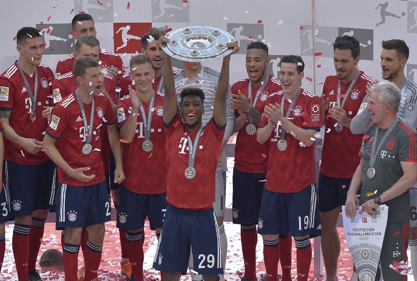 لاعب بايرن ميونيخ الفرنسي كينغسلي كومان يرفع كأس البوندسليغا  في 12 مايو 2018 - AFP
