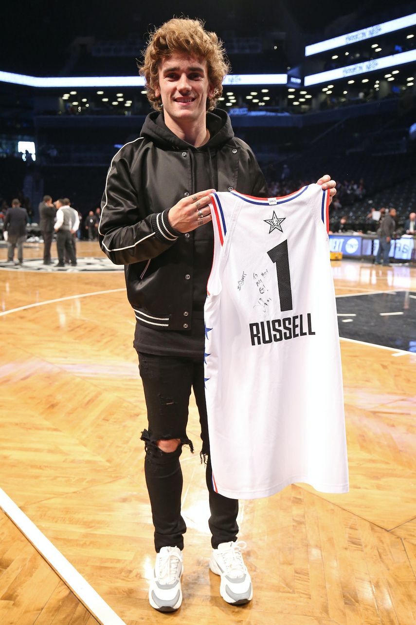 مهاجم برشلونة الفرنسي انطوان غريزمان يحمل قميص نجم كرة السلة الأمريكية روسيل - AFP