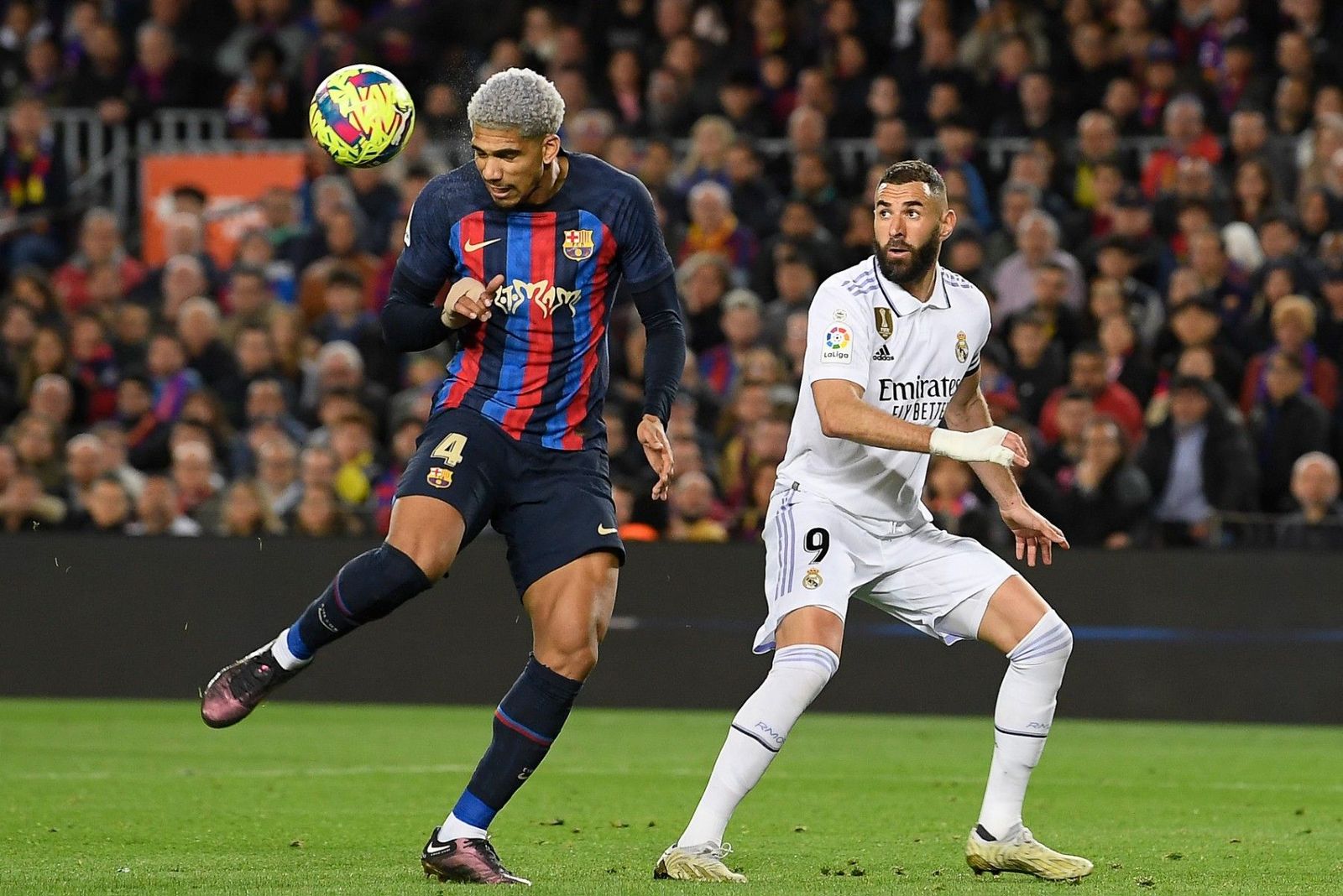 رونالد أراوخو مدافع برشلونة يضرب الكرة برأسه تحت أنظار كريم بنزيما قائد ريال مدريد في الكلاسيكو - 20 مارس 2023