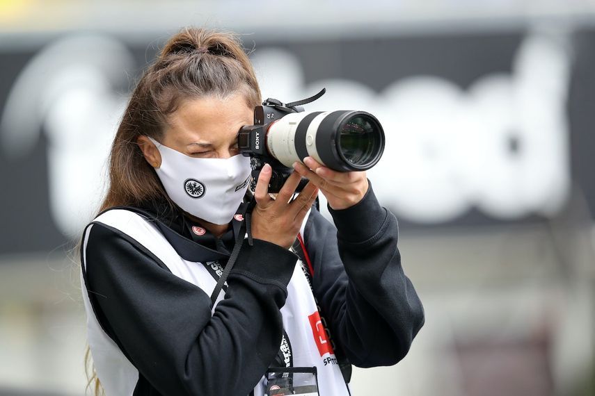 مصورة فوتوغرافية ترتدي قناع وجه أثناء تصويرها أحد مباريات البوندسليغا - AFP