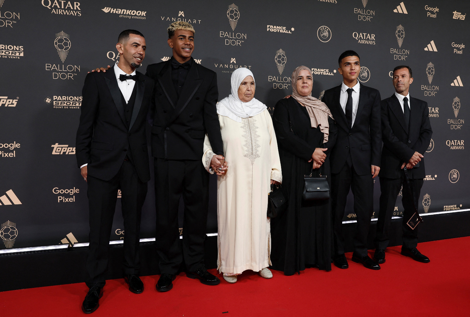 لامين يامال متوسّطاً والده منير نصراوي وجدته فاطمة مع أفراد آخرين من العائلة خلال حفل جائزة الكرة الذهبية - 22 سبتمبر 2025
